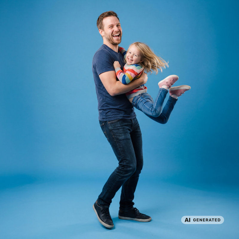 Ein Vater hält sein Kind in den Armen und beide lachen. (KI generiert)